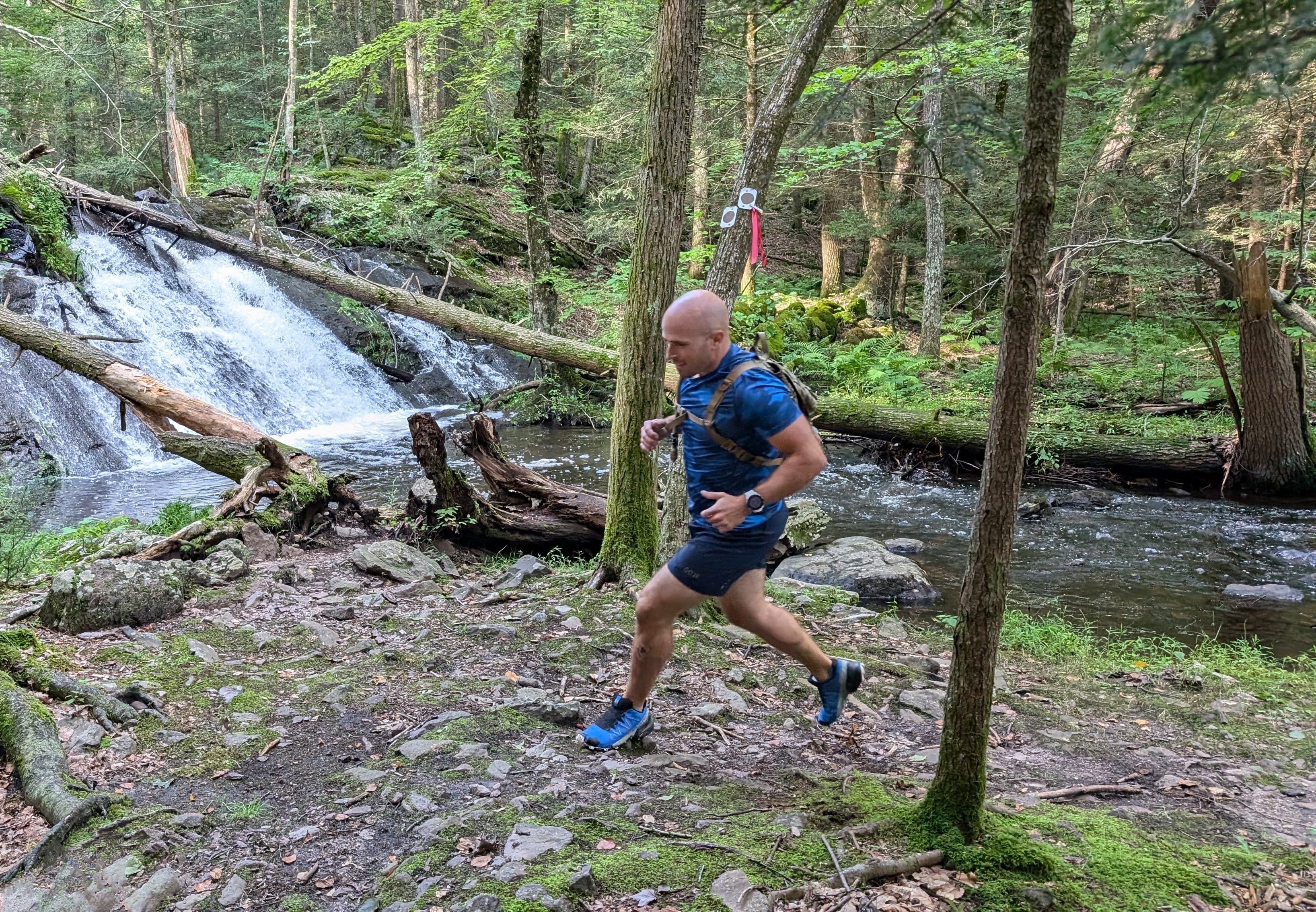 Daniel trail running near a waterfall